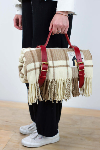 Checked woollen thrown in brown and cream with leather rug holder